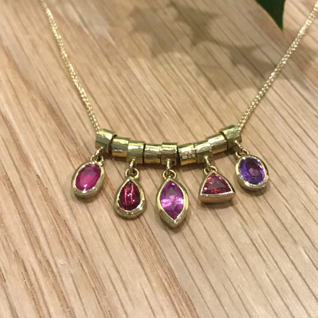 Showing stacking of gold pendants