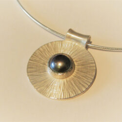 Dark pearl set in silver on medium rays silver disk pendant on silver
