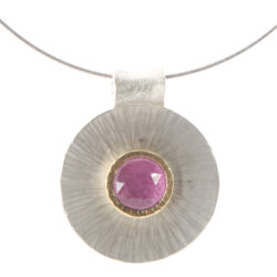 Chequerboard ruby set in gold on small rays disk as pendant on silver