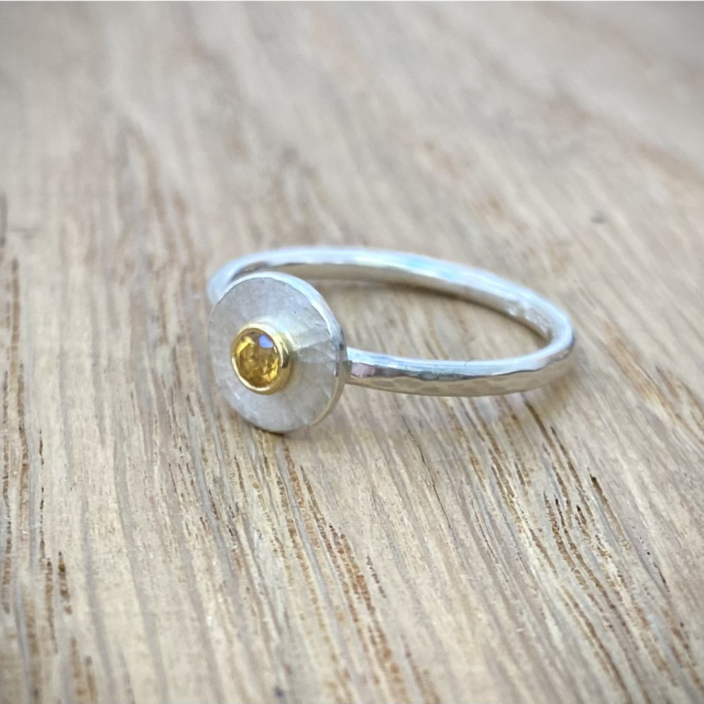 citrine in gold on round silver disk on silver band