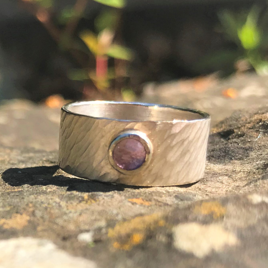 Amethyst in silver setting on wide silver rays band