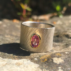 Pink spinel set in gold on wide rays silver band