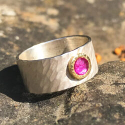 Rosecut ruby in yellow gold setting on wide rays silver band