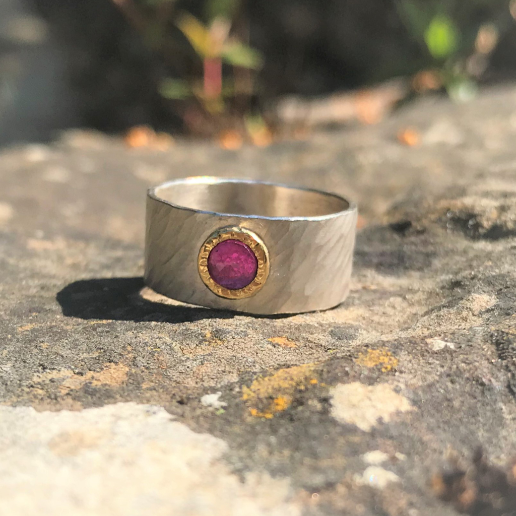 Rosecut ruby in yellow gold setting on wide rays silver band