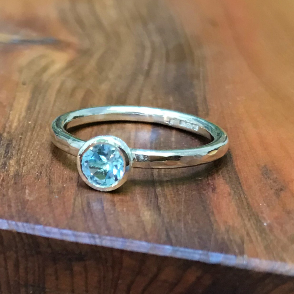 Pale blue Topaz in round silver setting on silver band