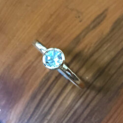 Pale blue Topaz in round silver setting on silver band