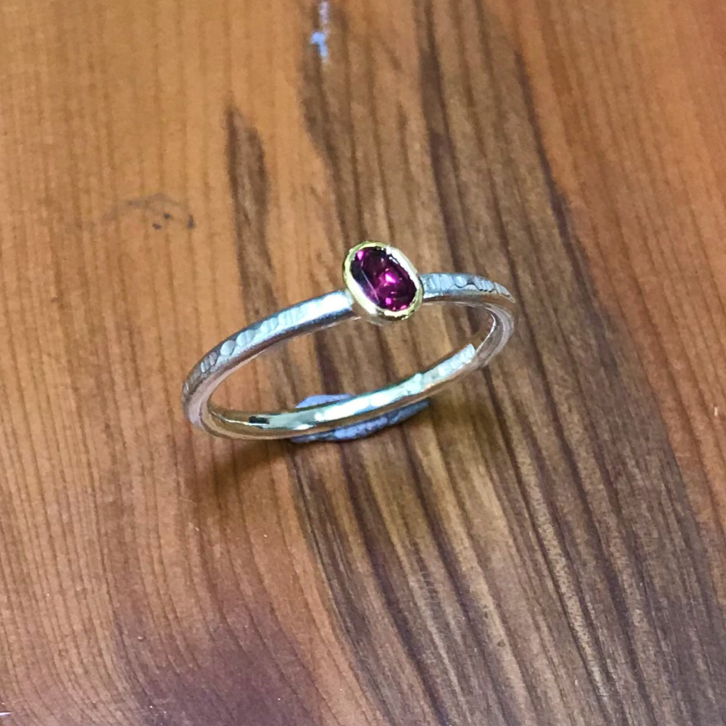 Oval purple garnet in gold setting on stacking silver band