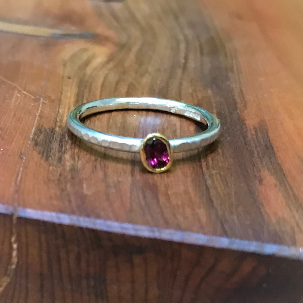 Oval purple garnet in gold setting on stacking silver band