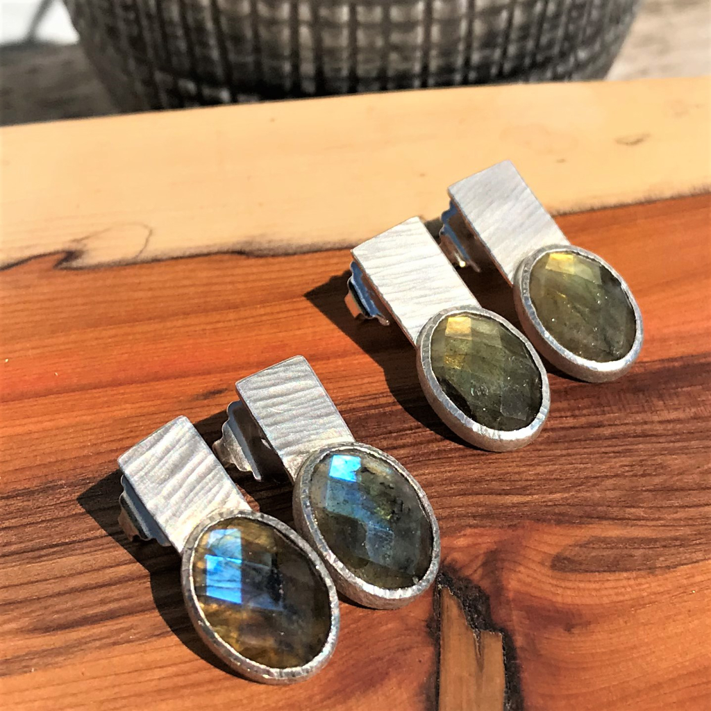 Earring of labradorite cabochon in silver setting on silver back piece