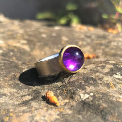 Amethyst set in gold on wide silver band