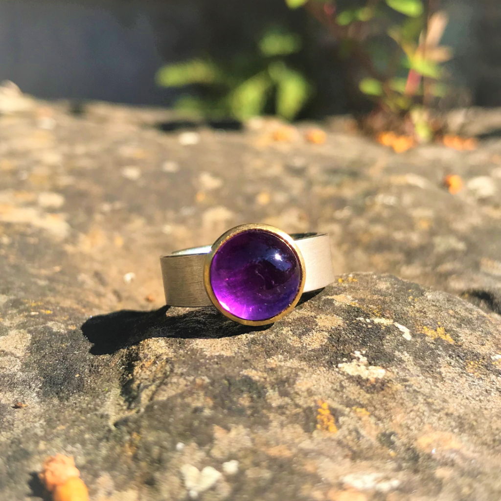 Amethyst set in gold on wide silver band