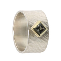 Square green sapphire set in green gold on a broad silver rays band