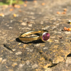 Pink spinel set in gold on rays gold band