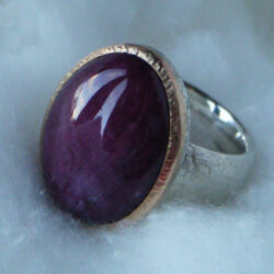 Ruby cabochon set in gold on silver hammered band