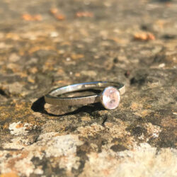 Stacking rose quartz in silver setting on slim silver band